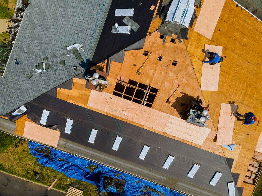 miami-new-roofing-construction-a-roofer-nailing-shingles